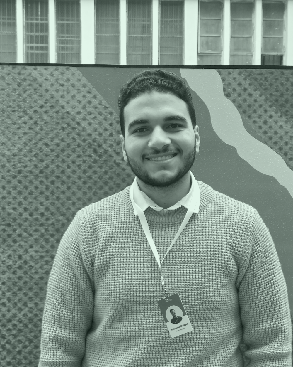 Mohannad El-Sayeh smiling, wearing a lanyard